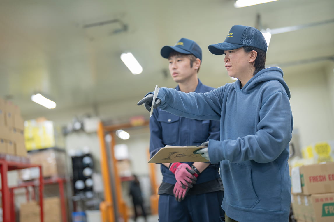 倉庫内で指示を出すスタッフと確認する作業員